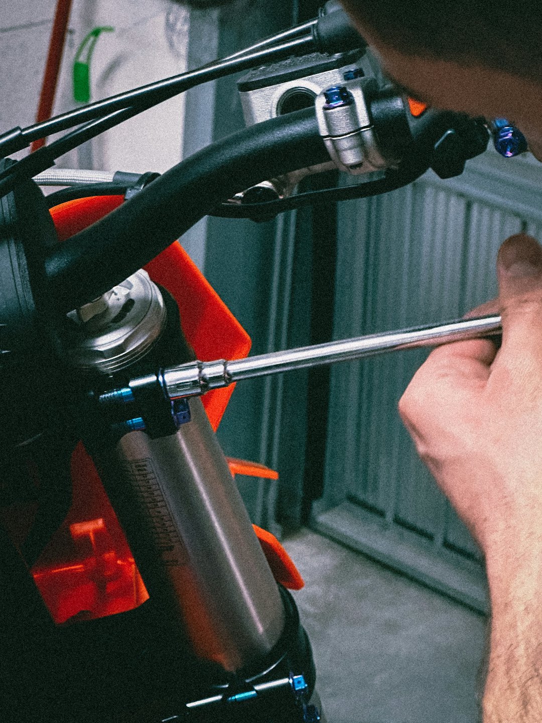 Un meccanico usa una chiave per regolare un bullone della sospensione di una moto.